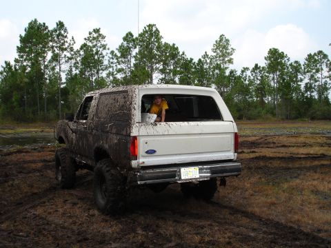 1989 Ford Bronco - This 1989 Ford Bronco is covered in mud after an off-road adventure, with a child peeking out from the back window.