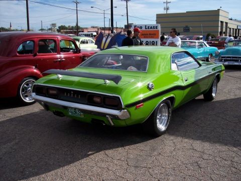1972 Ford Ranchero - A bright green Dodge Challenger is parked at a car show, with other vehicles visible in the background.