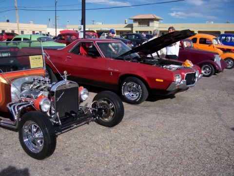 1972 Ford Ranchero - A red 1972 Ford Ranchero is displayed with its hood open at a car show, alongside other classic vehicles.