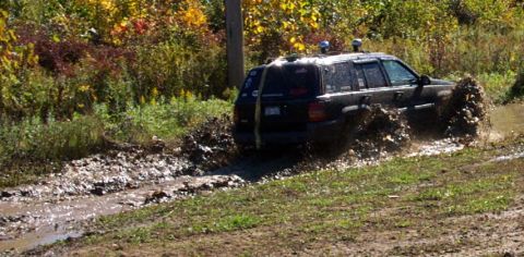 1979 Ford Bronco - SUV navigating a challenging muddy off-road course.