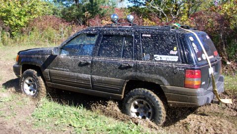 1979 Ford Bronco - Jeep Grand Cherokee navigates a challenging muddy off-road course.