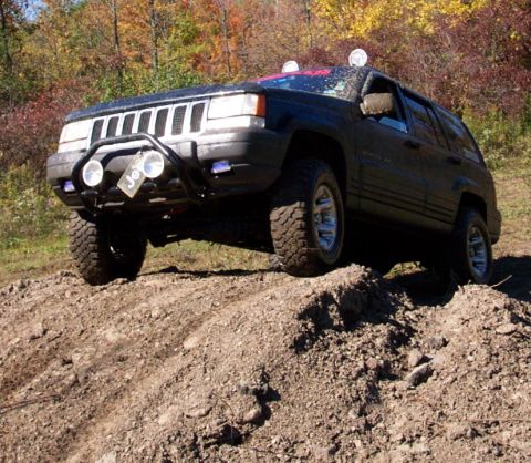 1979 Ford Bronco - A black Jeep Grand Cherokee navigates an off-road trail during autumn.