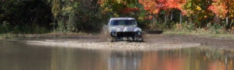 1979 Ford Bronco - 1979 Ford Bronco navigating a muddy trail during autumn.