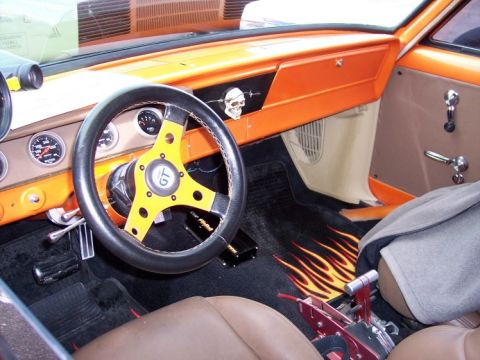 1972 Ford Ranchero - Custom interior features an orange dash, aftermarket steering wheel, and flame-patterned floor mats.