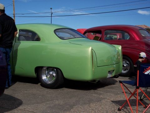 1972 Ford Ranchero - A customized green coupe is parked next to a red car at a car show.