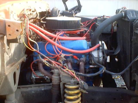 1976 Ford F-100 - Close-up of a V8 engine bay, focusing on the engine block, wiring, and air intake system.