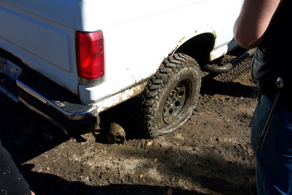 White vehicle's rear tire and fender, partially obscured