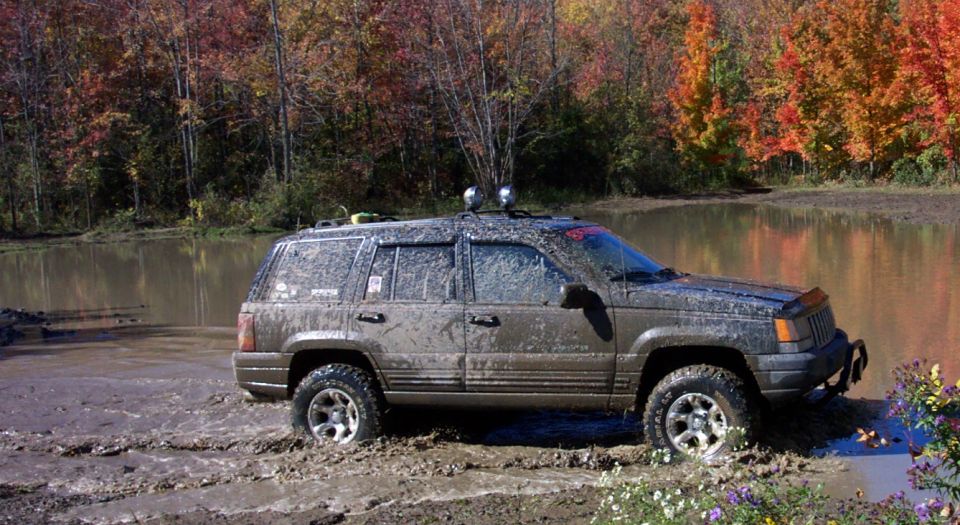 SUV parked on a dirt road with trees in the background