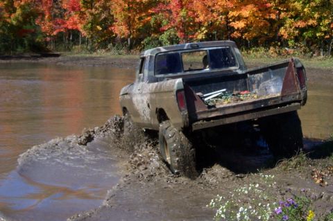 1979 Ford Bronco - 1979 Ford F-Series pickup truck navigates a muddy trail during autumn.