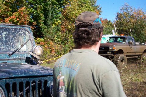 1979 Ford Bronco - Two off-road vehicles are seen in a muddy field during autumn.
