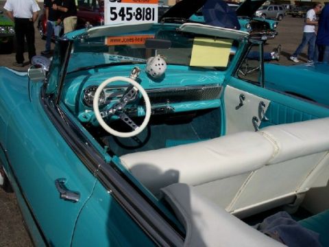 1972 Ford Ranchero - The interior of a turquoise convertible is shown, white seats and a white steering wheel.
