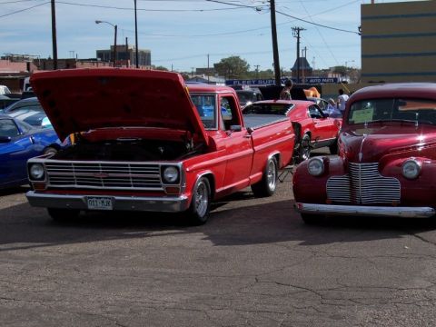 1972 Ford Ranchero - A red pickup truck is parked at an outdoor event with other vehicles visible.