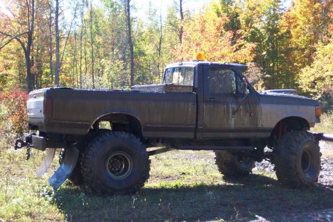1979 Ford Bronco - This heavily modified pickup truck features oversized tires and a plow, suggesting it's built for off-road or utility work.