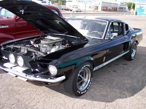 1972 Ford Ranchero - Black 1967 Ford Mustang Shelby GT500 at a car show, hood up revealing the engine.