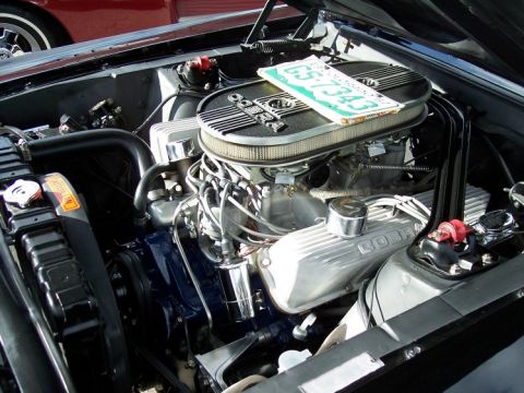 1972 Ford Ranchero - The engine bay of a car is visible, with a license plate placed on the air cleaner assembly.