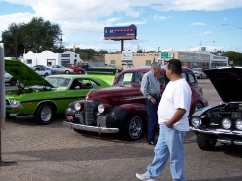 1972 Ford Ranchero - People admire classic cars at an outdoor car show on a sunny day.