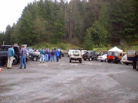 1976 Ford F-100 - A gathering of vehicles and people in a parking lot, with a white pickup truck prominently featured.