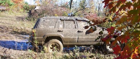 1979 Ford Bronco - This mud-covered SUV navigates a challenging off-road course during autumn.