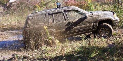 1979 Ford Bronco - Muddy Jeep Grand Cherokee stuck in a muddy ditch during off-roading.