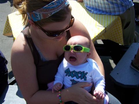1995 Ford Bronco - Baby wearing sunglasses and a "ROCK" shirt is held by a woman.