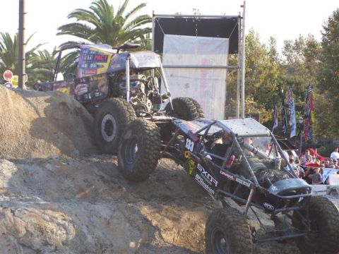 1995 Ford Bronco - These custom buggies are competing on a challenging dirt course with spectators watching.