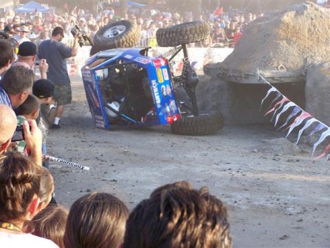 1995 Ford Bronco - An off-road vehicle has overturned during an event, with spectators gathered around.