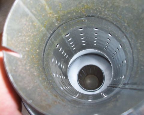 1994 Ford F-150 - Close-up view inside a vehicle's exhaust muffler, showing the perforated inner pipe and baffle system.