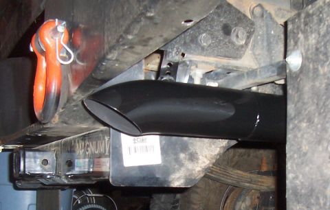 1994 Ford F-150 - Close-up view of a vehicle's exhaust pipe tip and a tow hitch with an orange shackle attached.