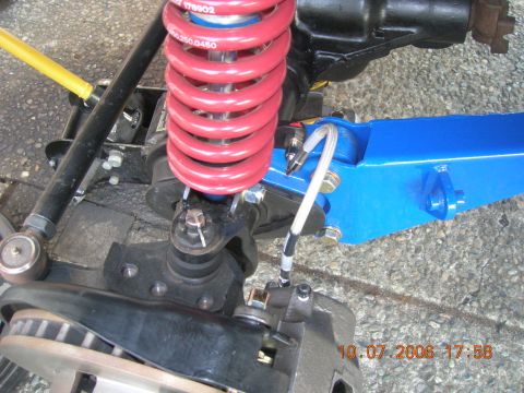 1996 Ford Bronco - Close-up of vehicle suspension parts, including a red coilover shock and blue control arm.