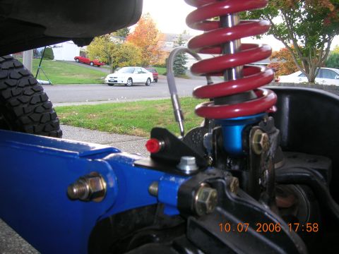 1996 Ford Bronco - Close-up of modified suspension components with a street scene in the background.