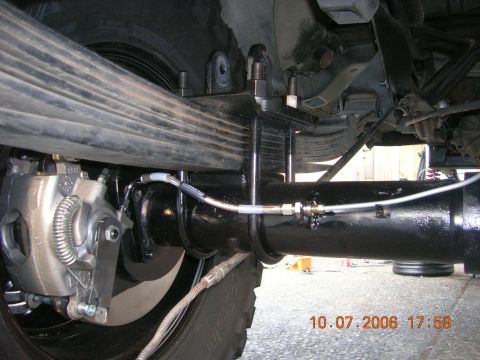1996 Ford Bronco - Close-up view of the rear axle and suspension system, including the leaf springs and brake caliper.