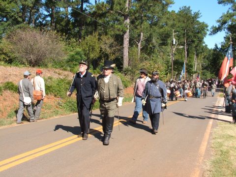 1966 Ford Ranchero - A group of Civil War reenactors, dressed in period uniforms, march down a road during a parade, accompanied by flags and drums.