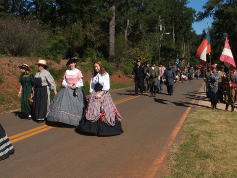 1966 Ford Ranchero - A group of people in historical reenactment attire walk down a road, some carrying flags.