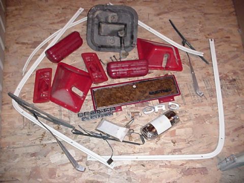 1979 Ford Bronco - Collection of red interior trim pieces, including door panels and taillights, along with 'BRONCO CUSTOM' and 'FORD' emblems, likely for a 1…