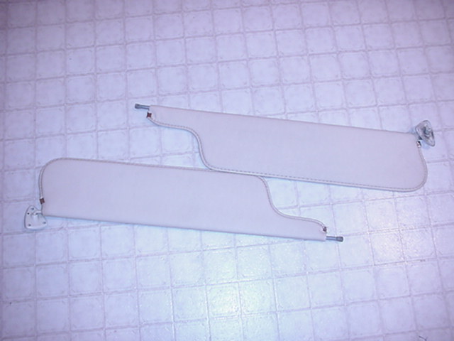 Pair of light-colored sun visors with metal mounting hardware