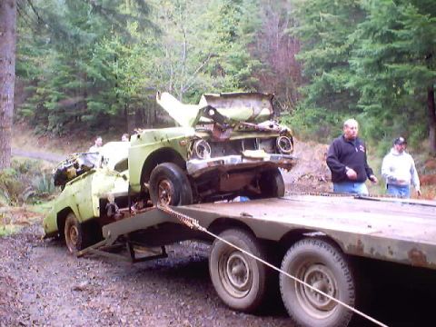 1976 Ford F-100 - This heavily damaged 1976 Ford F-100 pickup truck is being transported on a flatbed trailer.