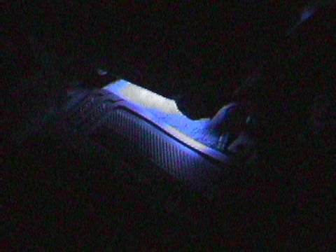 1994 Ford Bronco - Interior dashboard lighting glows blue over a textured surface.