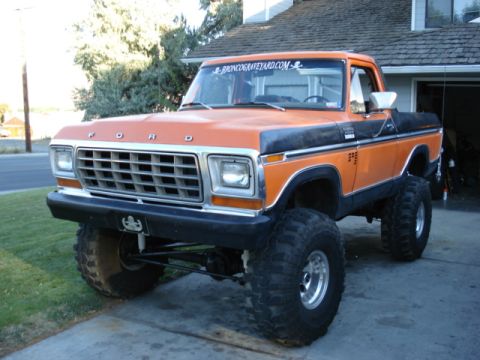 1994 Ford Bronco - This lifted Ford truck features a prominent grille and large off-road tires.
