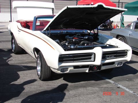 1987 Ford Bronco - White 1969 Pontiac GTO convertible shows off its engine, with a silver car visible in the background.