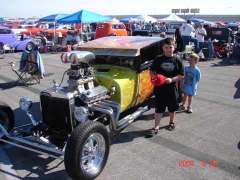 1987 Ford Bronco - A custom hot rod is displayed at an outdoor event with spectators and other vehicles present.