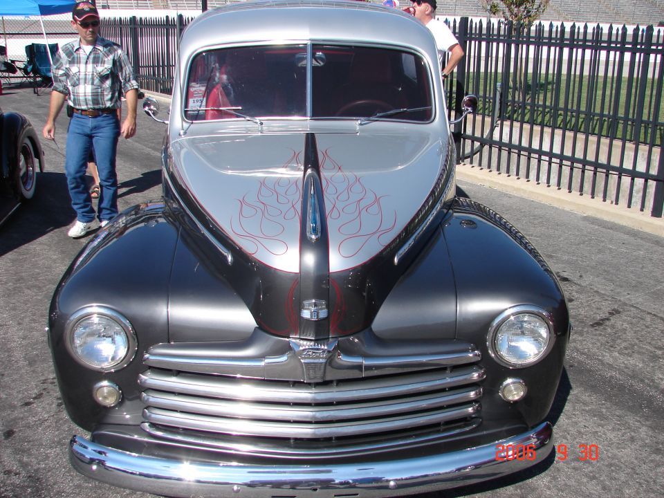 Two-tone classic car front view with chrome grille and flame decals on hood