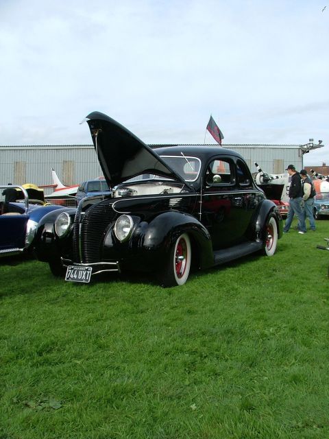 2001 Ford Fiesta - This black coupe, likely a 1940 model, is displayed with its hood open, red wheels and white wall tires.