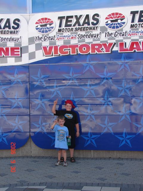 1987 Ford Bronco - Two children pose in front of a Texas Motor Speedway Victory Lane backdrop.