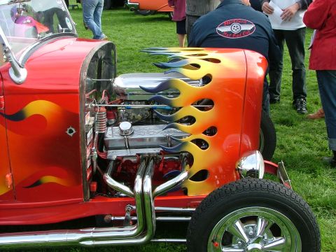 2001 Ford Fiesta - A custom hot rod with a vibrant flame paint job and a powerful engine is displayed on a grassy field.