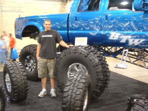 2004 Toyota Tacoma - Custom blue pickup truck with oversized tires and unique graphics displayed indoors.