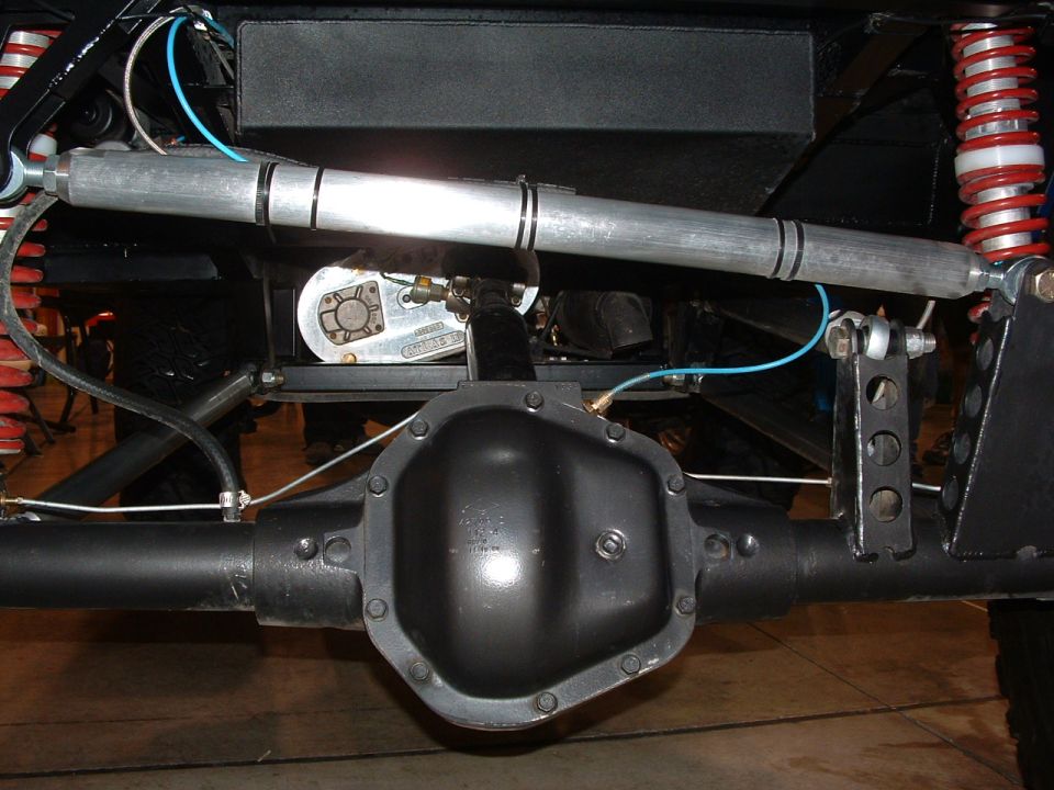 Rear axle assembly with red coilover shocks and silver steering stabilizer