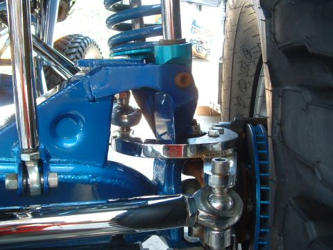 2004 Toyota Tacoma - Close-up of modified vehicle suspension with shiny chrome and bright blue paint.