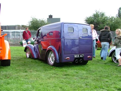 2001 Ford Fiesta - A custom van with a unique purple paint job and chrome accents is parked on a grassy field.