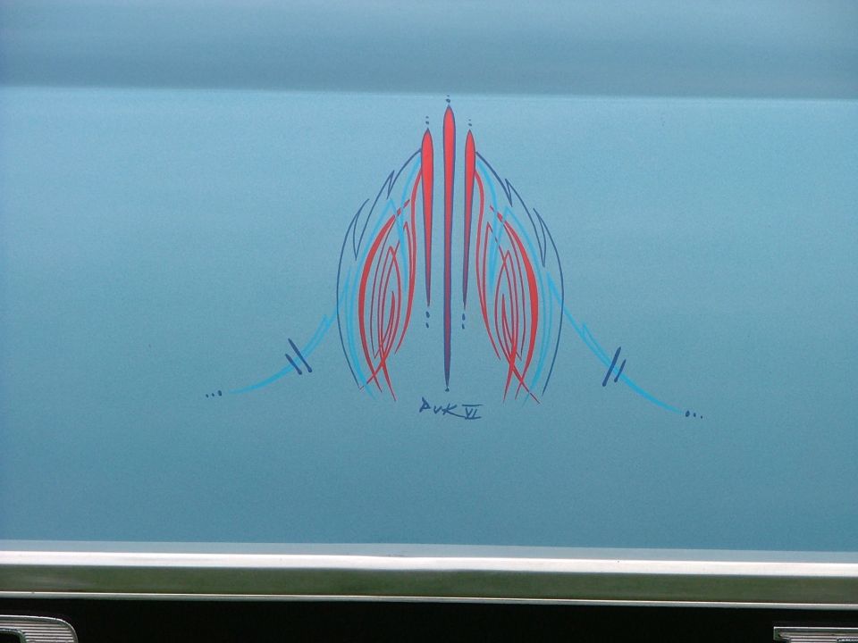 Blue vehicle with red and blue pinstripe art and artist signature 'DVK VI'