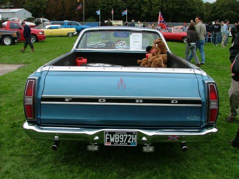1970 Ford Ranchero - Rear view of a blue 1970 Ford Ranchero pickup truck parked on grass with other vehicles in the background.
